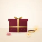 Burgundy gift box with gold ribbon, brass diya and tealight